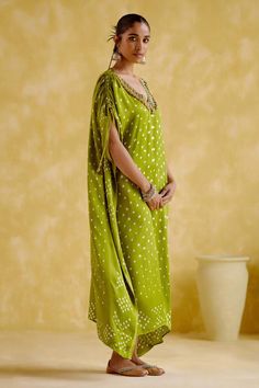 Green kaftan with bandhani print, ghungroo embroidered V neckline and flared sleeves.
Components: 1
Pattern: Printed, Embroidered
Type Of Work: Bandhani, Ghungroo
Neckline: V Neck
Sleeve Type: Flared Sleeves
Fabric: Modal satin lagdi patta
Color: Green
Other Details: 
Length : Approx 54 inches, Lengths may vary as per size and height
Occasion: Sangeet - Aza Fashions Bandhani Pattern, Green Kaftan, Kaftan Women, Bandhani Print, Kaftan For Women, Types Of Work, Flared Sleeves, Aza Fashion, V Neckline