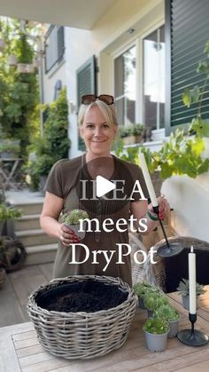 a woman standing in front of a basket filled with dirt and plants next to a potted plant