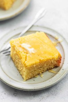 a piece of cornbread cake on a plate with a fork next to the slice