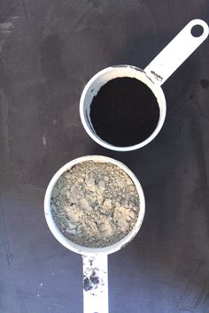 two white measuring spoons filled with black powder