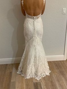 a woman in a wedding dress looking at her back