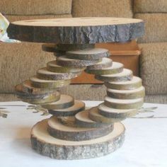 a table made out of logs on top of a white tablecloth covered floor next to a couch