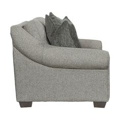 a gray chair with two pillows on the armrests and a pillow sitting on top of it