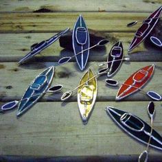 several canoes and kayaks sitting on top of a wooden table next to each other