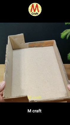 someone is holding up a box with the bottom half cut off and inside it, which has been made out of cardboard