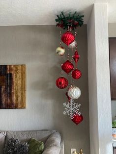 a living room with christmas decorations hanging from the ceiling and a couch in front of it