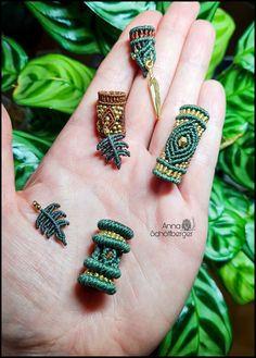 three different rings in the palm of someone's hand with green leaves behind them