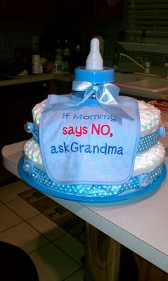 a diaper cake sitting on top of a kitchen counter next to a bottle filled with liquid