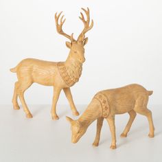 two wooden deer figurines standing next to each other