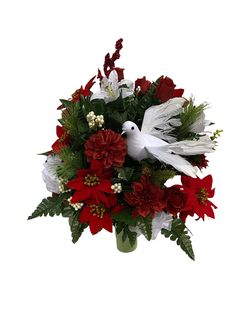 a white bird sitting on top of a vase filled with red flowers and greenery