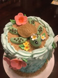 there is a cake that looks like a turtle on top of the sand and flowers