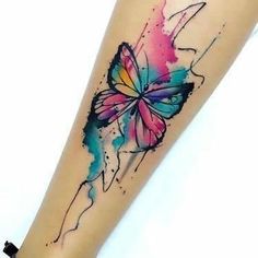 a colorful butterfly tattoo on the right forearm and leg, with watercolor splashs