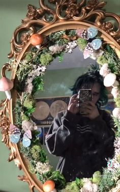 a woman taking a selfie in front of a mirror with flowers and plants on it