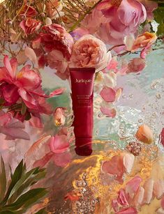 a close up of a tube of skin care on a table with flowers and water