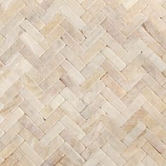 a close up view of a white and beige herringbone tile flooring pattern that looks like it has been cut in half