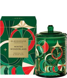 glasshouse winter wonderland candle in green with red and gold design on the lid, next to a box