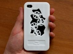 a hand holding a white case with gears on the front and back cover for an iphone 4 / 4s