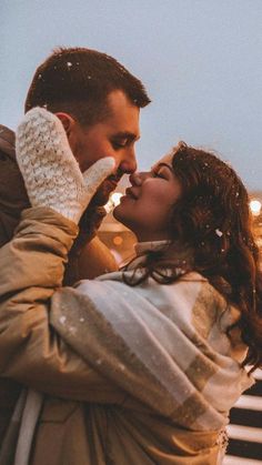 a man and woman standing next to each other in front of a street light at night