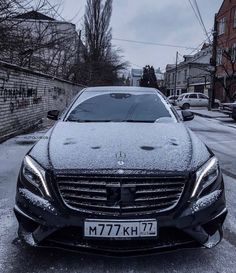 a mercedes benz s - class parked on the side of a road covered in snow