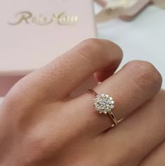 a woman's hand with a diamond ring on it