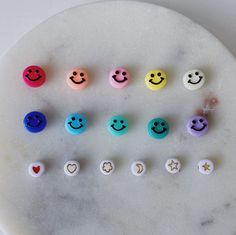 six different colored smiley faces on a marble plate