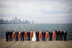 a group of people standing next to each other on a pier in front of the ocean