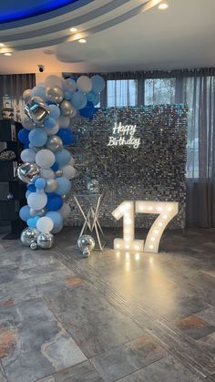 the balloon arch is decorated with blue and silver balloons