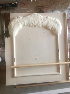 a piece of white paint sitting on top of a wooden frame