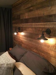 a bedroom with wood walls and lights on the headboard