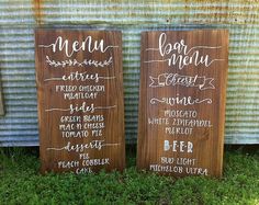 two wooden signs sitting in the grass next to each other