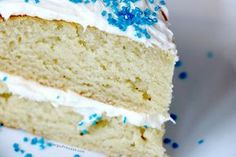 a slice of cake with white frosting and blue sprinkles