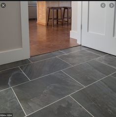 an open door leading to a kitchen with stools and counter tops in the background