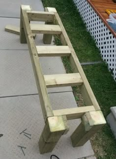 a wooden bench sitting on top of a sidewalk