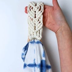 a hand holding a blue and white tie - dyed towel with knotting on it