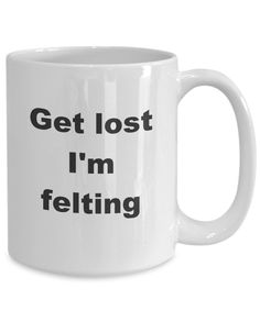 a white coffee mug with the words get lost i'm felting on it