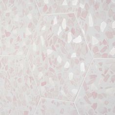 a pink and white wall with hexagonal tiles