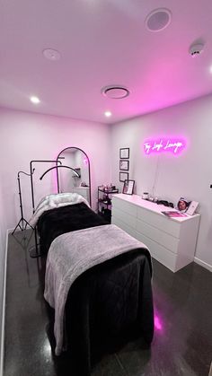 two beds in a room with pink lights on the ceiling and black bed linens