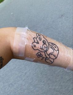 a person's arm with a tattoo on it that has a cartoon character drawn on it