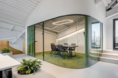 an office with glass walls and green carpeted flooring is pictured in this image