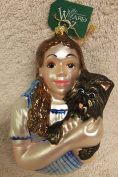 a ceramic figurine is holding a dog