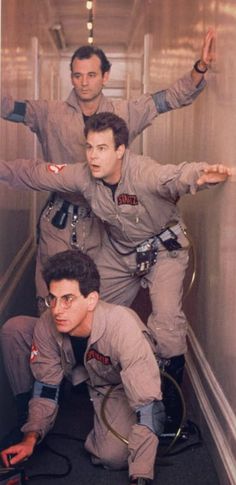 three men in space suits are posing for the camera while another man is standing behind them