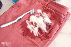 a toothbrush is sitting on top of a red t - shirt that has been smothered with white stuff