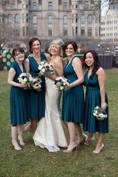 a group of women standing next to each other on top of a grass covered field