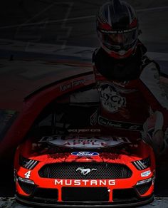 a red mustang racing car with a helmet on