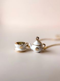 two white teapots sitting next to each other on top of a table together