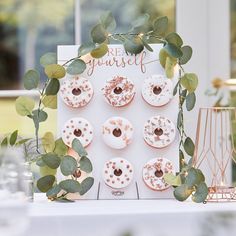 there are donuts on the table with greenery