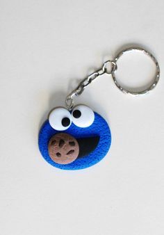 a cookie monster keychain is shown on a white surface, with eyes and nose