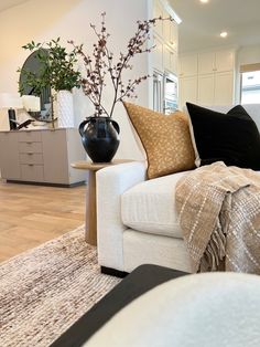 a living room filled with furniture and a vase on top of a table next to a couch