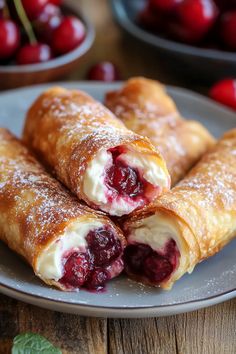 cranberry and cream filled pastries on a plate with cherries in the background