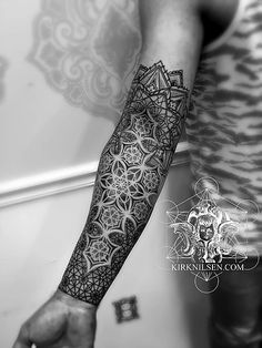 a man's arm with an intricate tattoo design on the left side of his arm